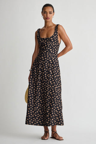Woman wearing a black floral dress against a white background