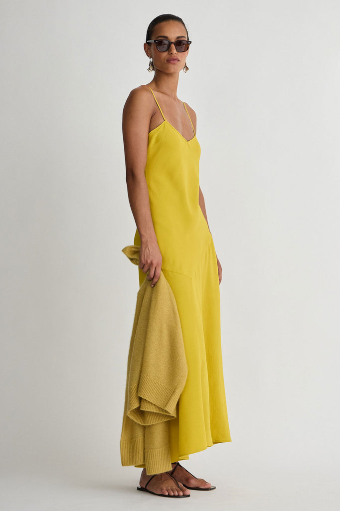 Woman wearing a yellow dress on a white background