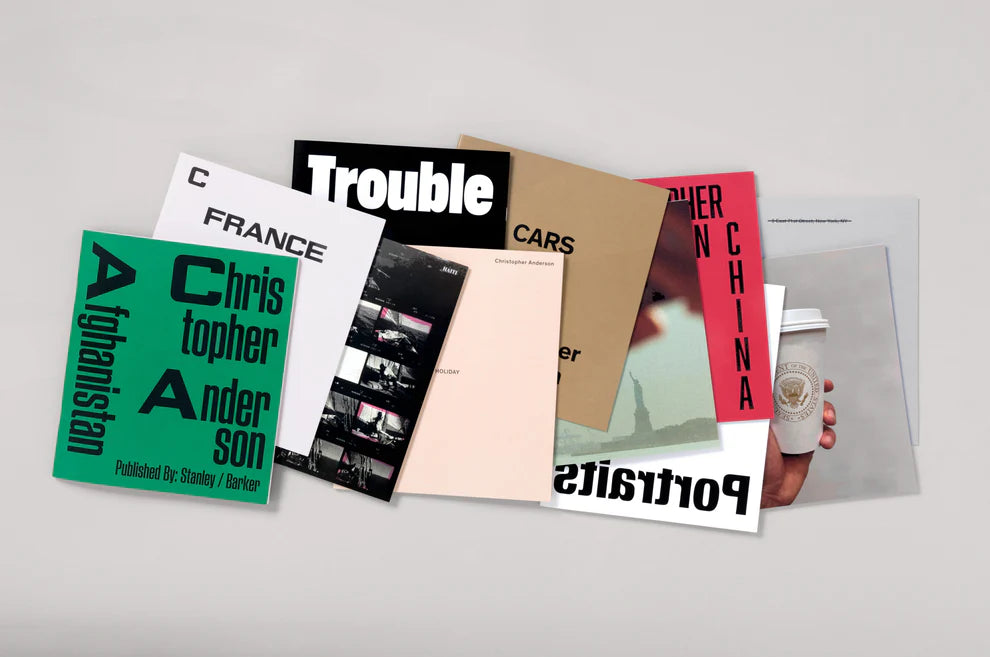 Collection of books or photo albums with various covers on a light gray background