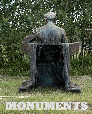 Cover of book showing an image of A bronze monument of a man seen from behind, seated in a high-backed chair outdoors in a grassy area with trees. The word monuments written along the bottom in white