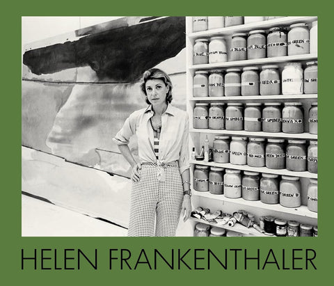 Black and white photo of artist Helen Frankenthaler in her studio by shelves of paint jars and a canvas, include something about text and green surround.