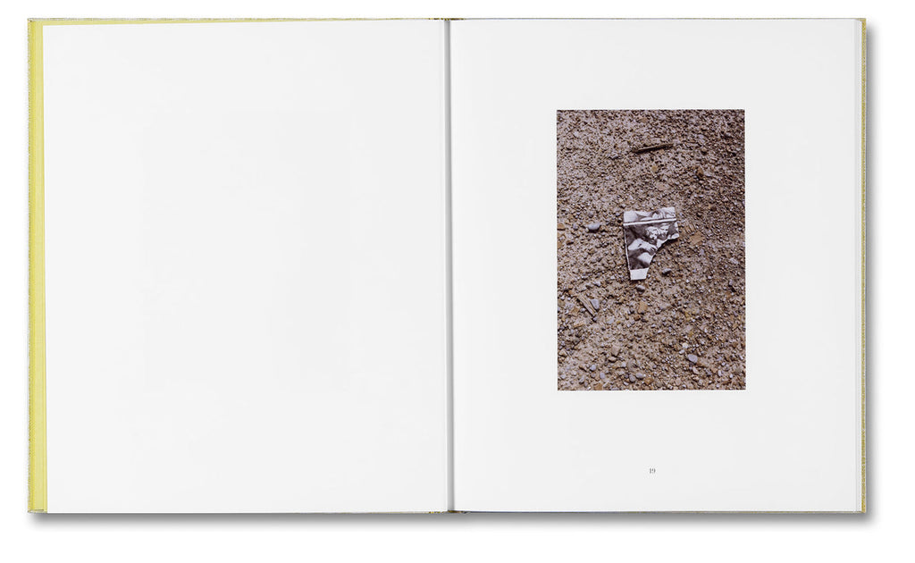 Open book with a photograph of a small object on a textured surface