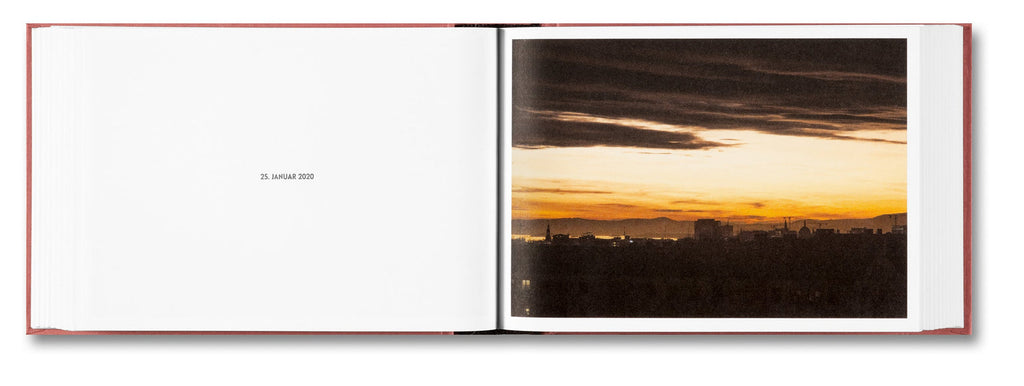 Open book showing a photograph of a sunset over a cityscape.