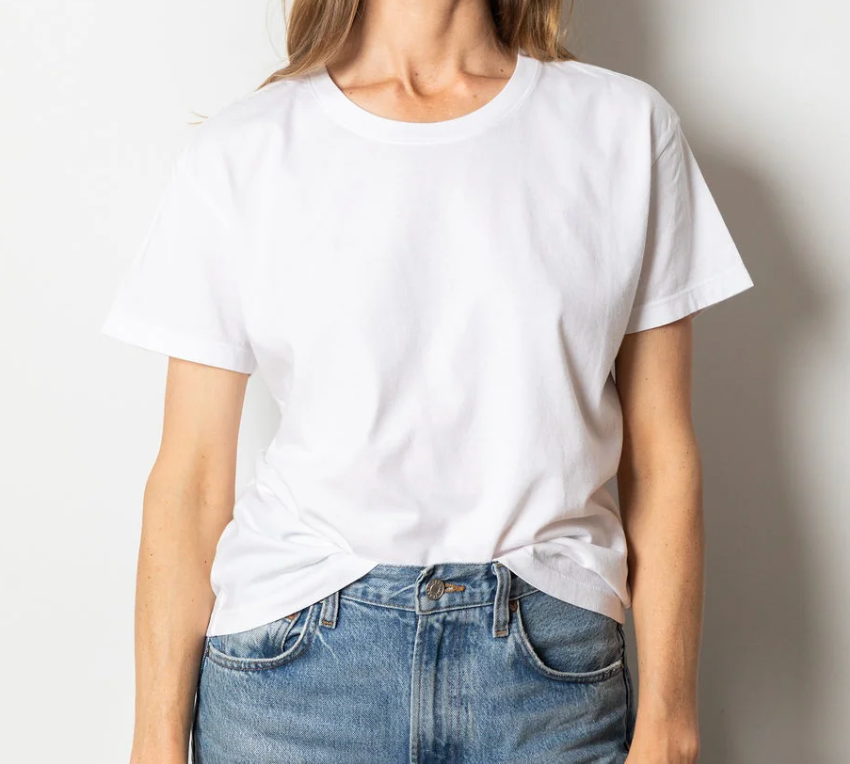 White short-sleeve crewneck t-shirt tucked into blue jeans, shown from the chest down.