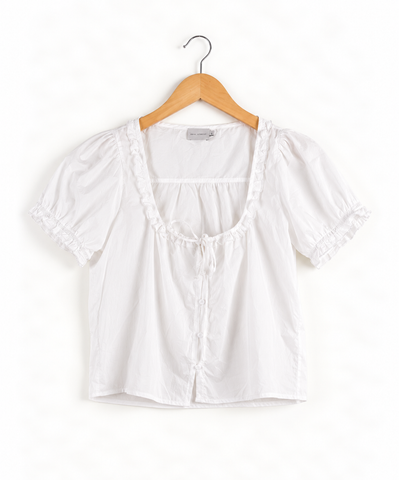 White cotton poplin short sleeve top with a square frill neckline and drawstring tie at the centre front on wooden hanger against white background