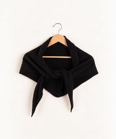 black shawl on a hanger against white wall
