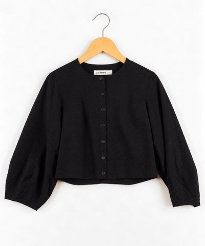 Zii Ropa dark navy cropped long-sleeve button-up top with textured fabric and wide sleeves, hanging on a wooden hanger against a white background.