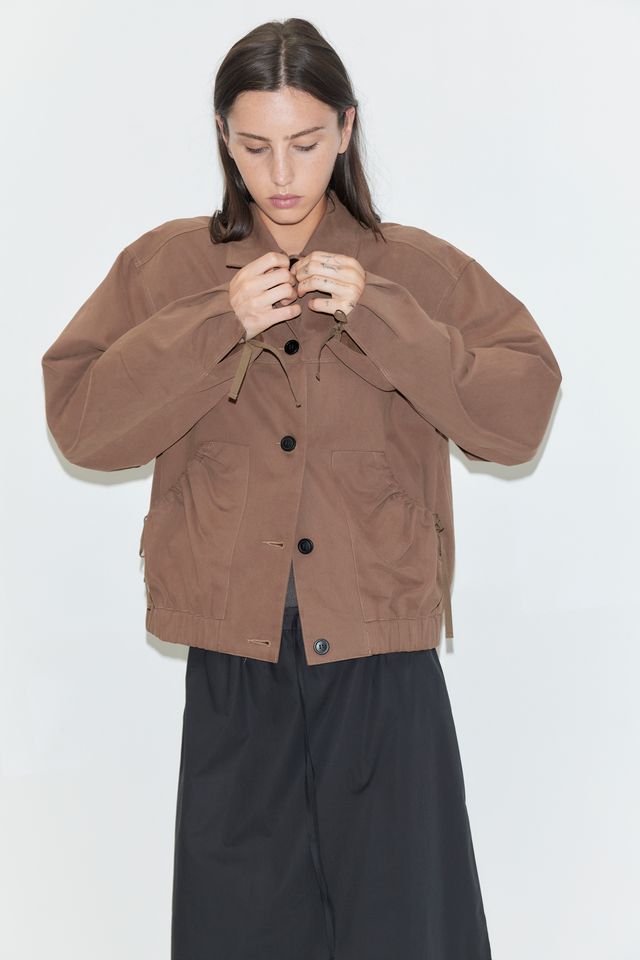 Woman wearing a brown jacket on a white background