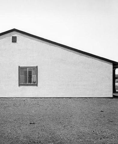 Black and white photo of a building with a window on a plain background